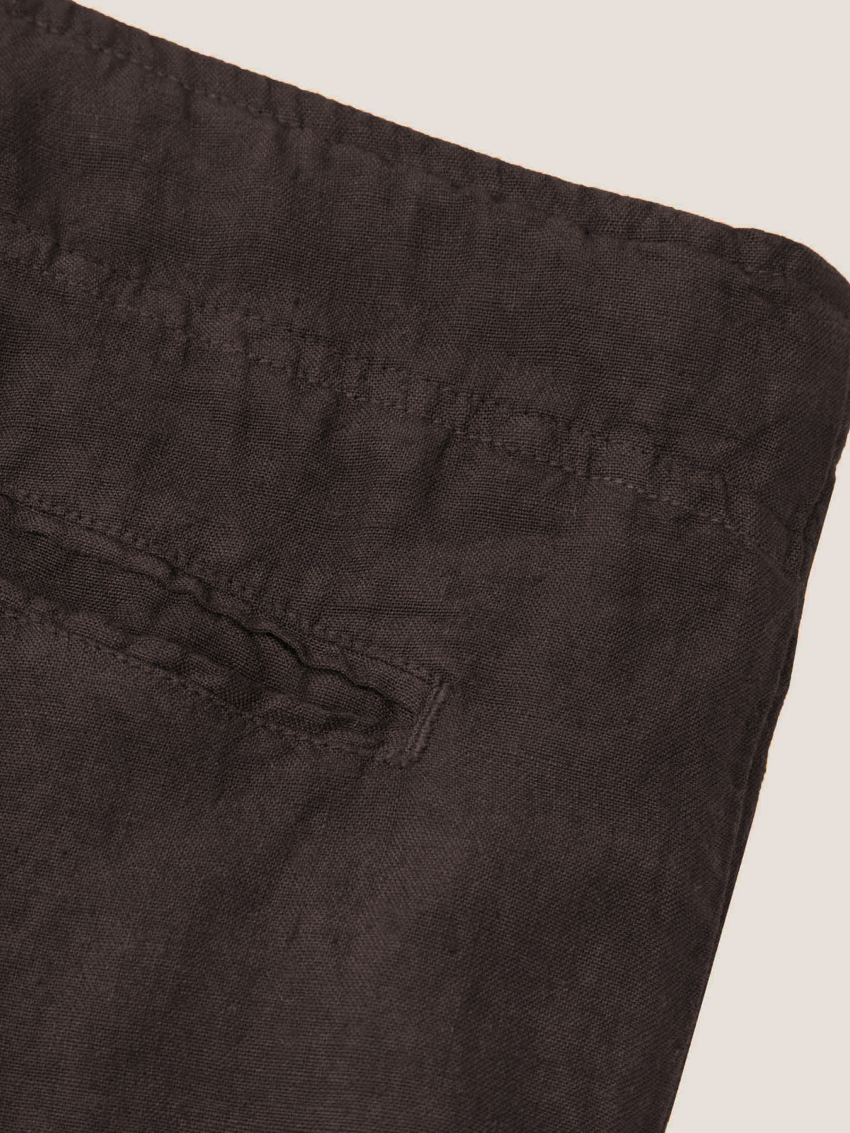 A close-up detail shot of the back pocket and waistband of the Chocolate Brown Lipari Linen Trousers.