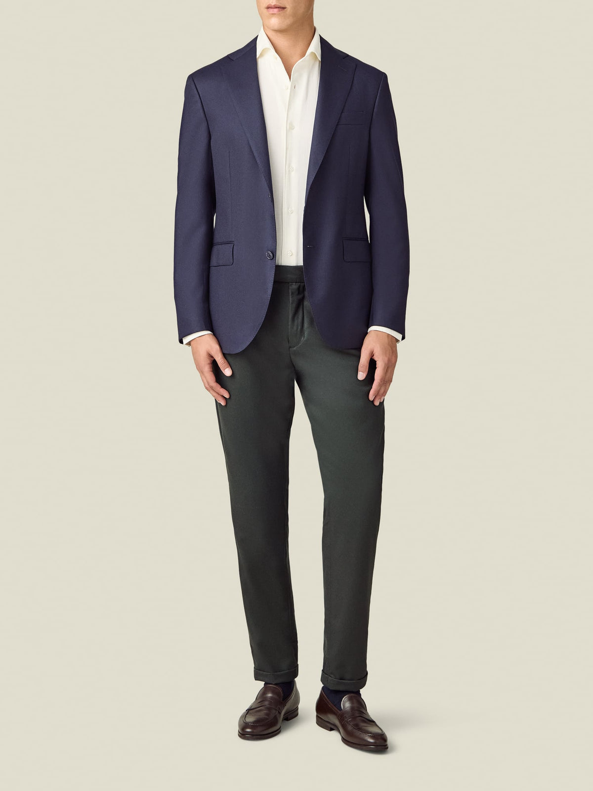 Full view of a model wearing the Luca Faloni Wool Pleated Trousers in khaki green, styled with a white shirt and navy blazer.