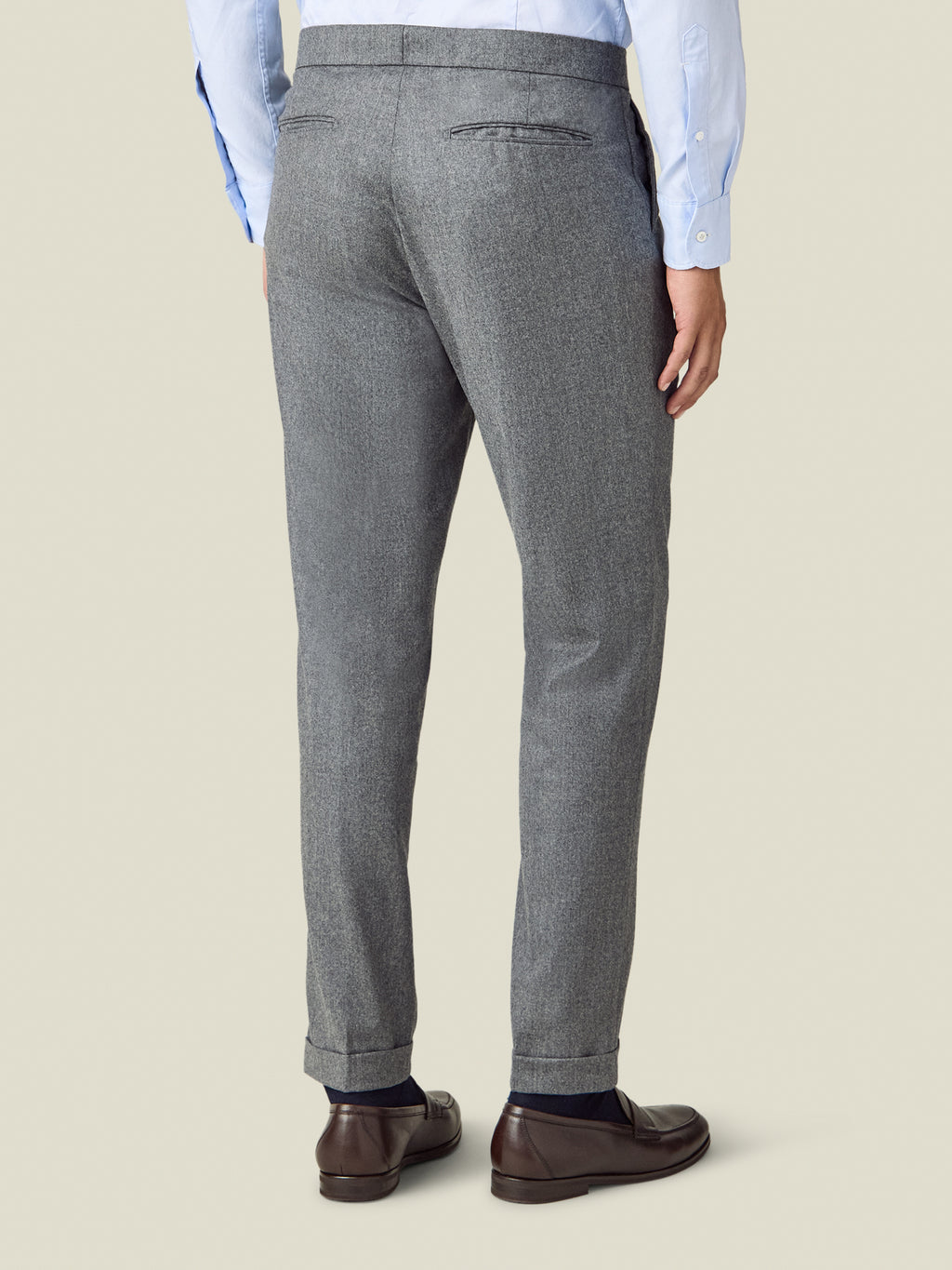 Back view of a man wearing the Luca Faloni Wool Pleated Trousers in light grey.