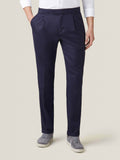 Front view of a man wearing Midnight Blue Wool Pleated Trousers with a white shirt and grey suede sneakers.