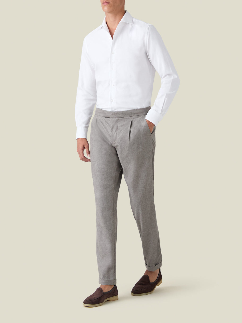 Front view of a model wearing the Luca Faloni Camel Beige Wool Pleated Trousers with a white shirt and dark brown loafers.