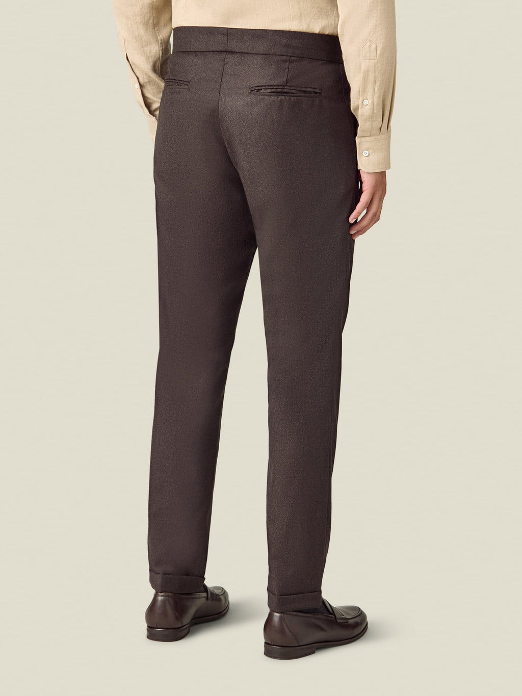 Back view of a model wearing the Luca Faloni Wool Pleated Trousers in chocolate brown.