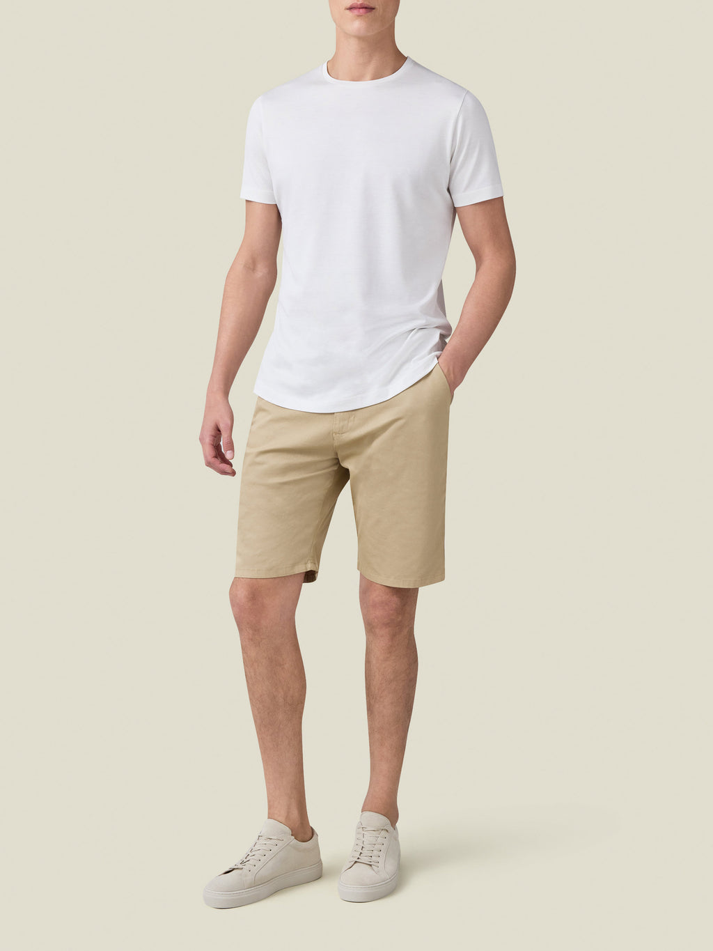 Model wearing Luca Faloni's white Silk-Cotton T-Shirt with beige shorts and white sneakers against a neutral background.
