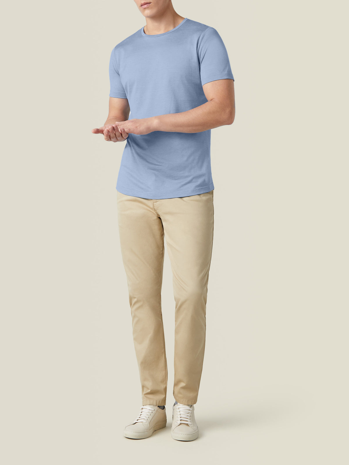 A model wears the Luca Faloni Silk-Cotton T-Shirt in light blue, styled with beige trousers and white trainers.