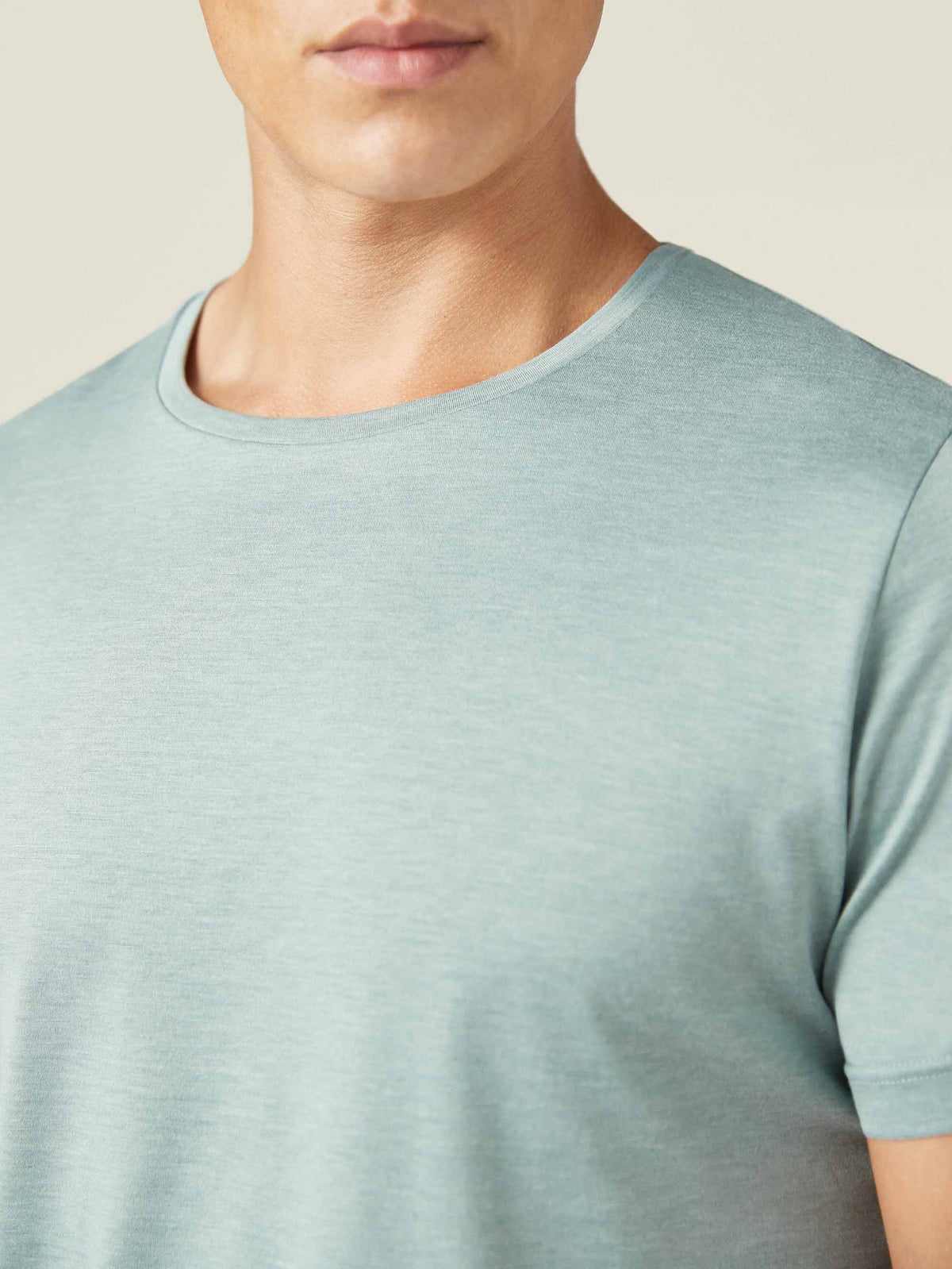 A close-up of a man wearing the Marine Green Silk-Cotton T-Shirt, showing the detail of the crew neckline and fabric.