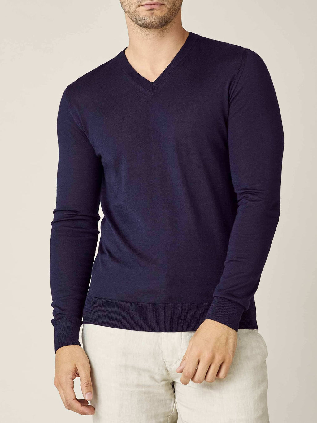 Model seen from the front wearing the Luca Faloni silk-cashmere v-neck jumper in navy blue with light trousers.