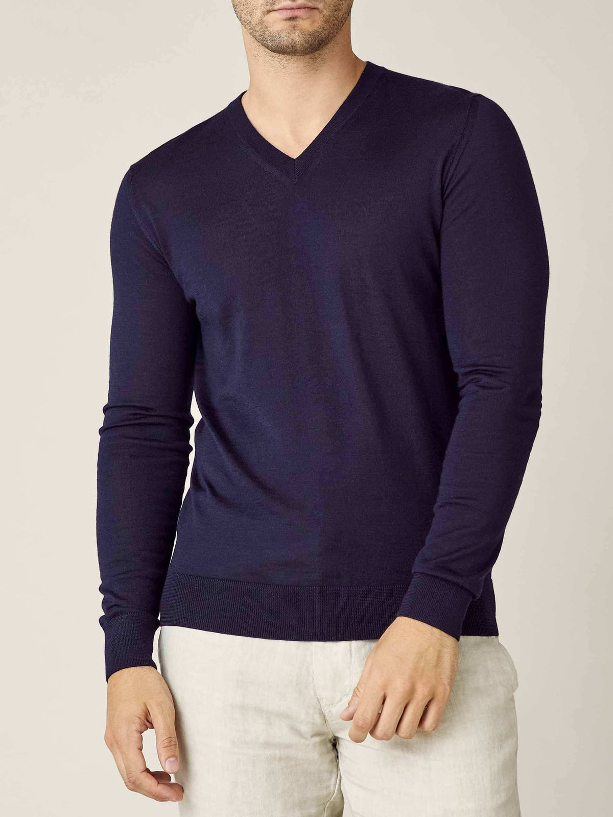 Model seen from the front wearing the Luca Faloni silk-cashmere v-neck jumper in navy blue with light trousers.