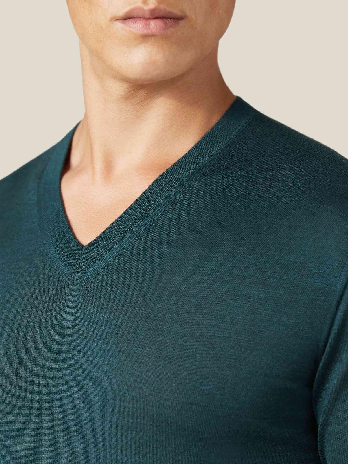 Close-up of a man wearing the Forest Green Silk-Cashmere V-Neck, showing the ribbed neckline and fine knit texture.