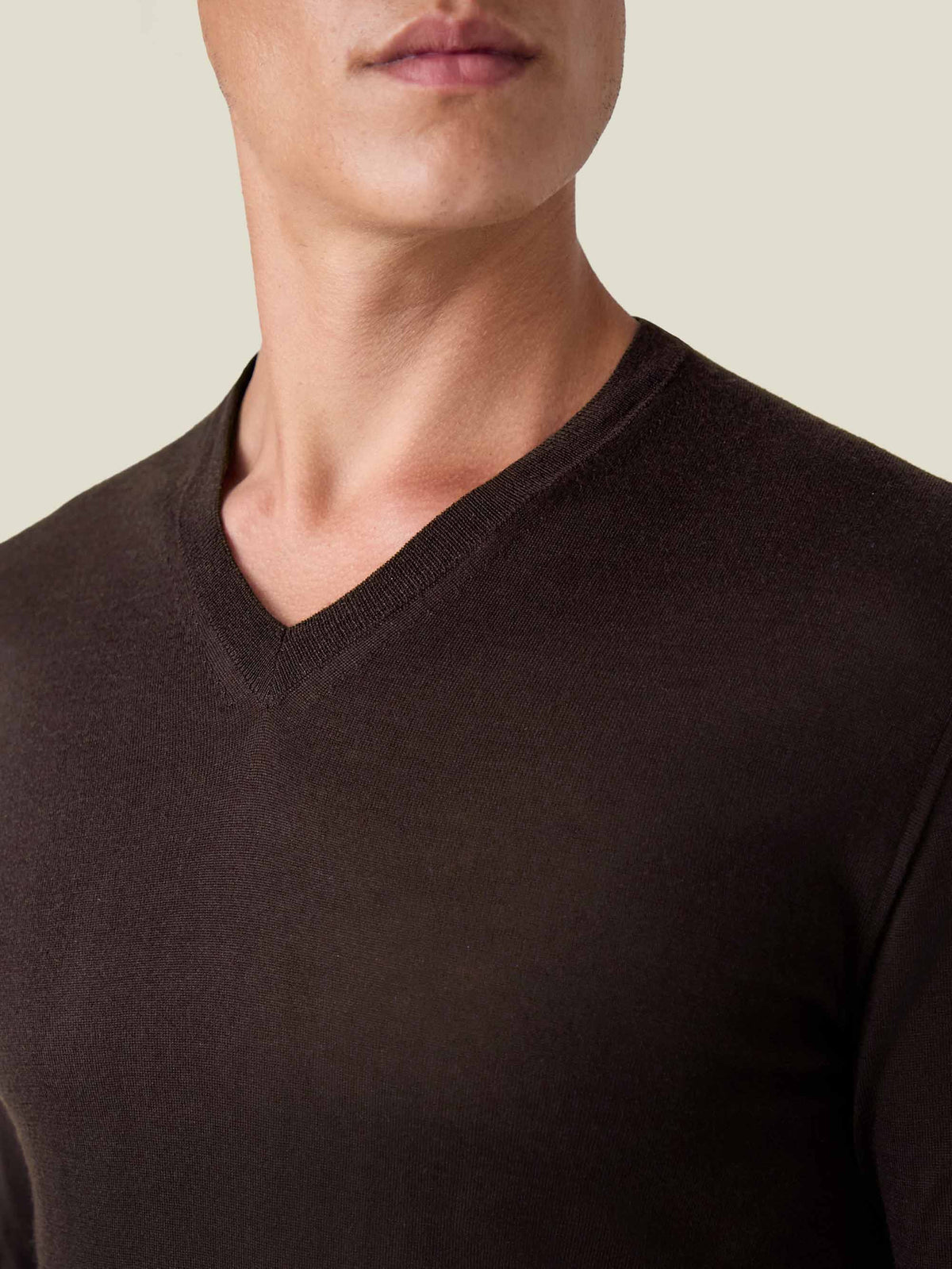 Close-up of a man wearing a Luca Faloni chocolate brown silk-cashmere V-neck sweater, highlighting the neckline.