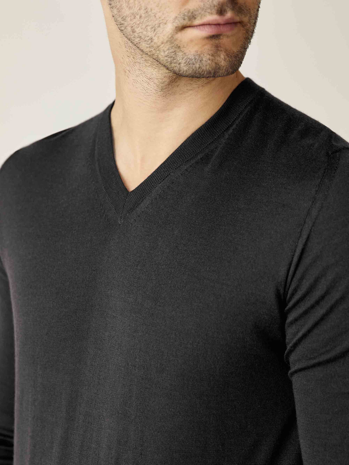 A close-up of a model wearing the Charcoal Grey Silk-Cashmere V-Neck, highlighting the ribbed neckline and fine knit.