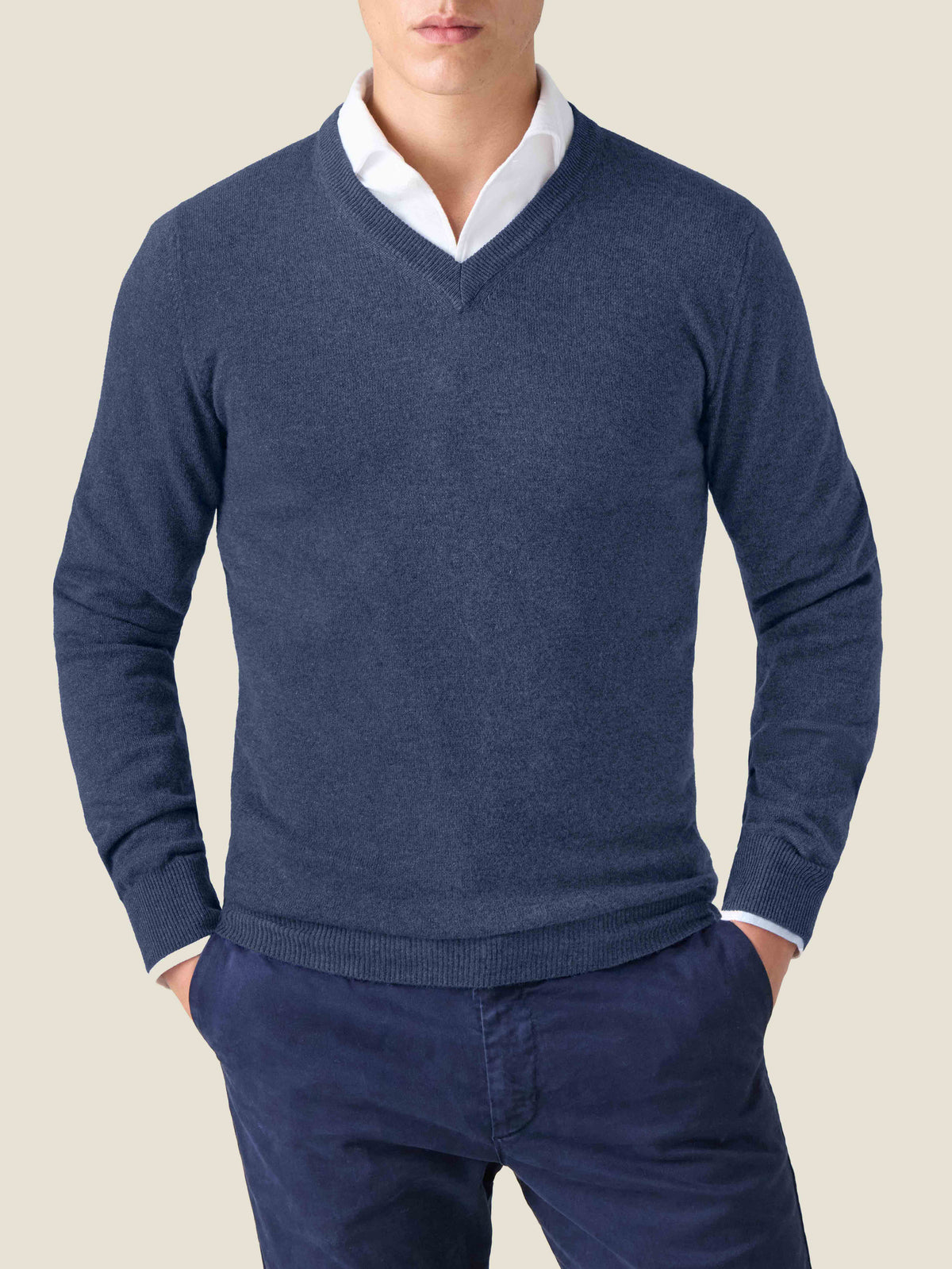 Model wears the Luca Faloni Atlantic Blue Cashmere V-Neck layered over a white shirt and paired with navy trousers.