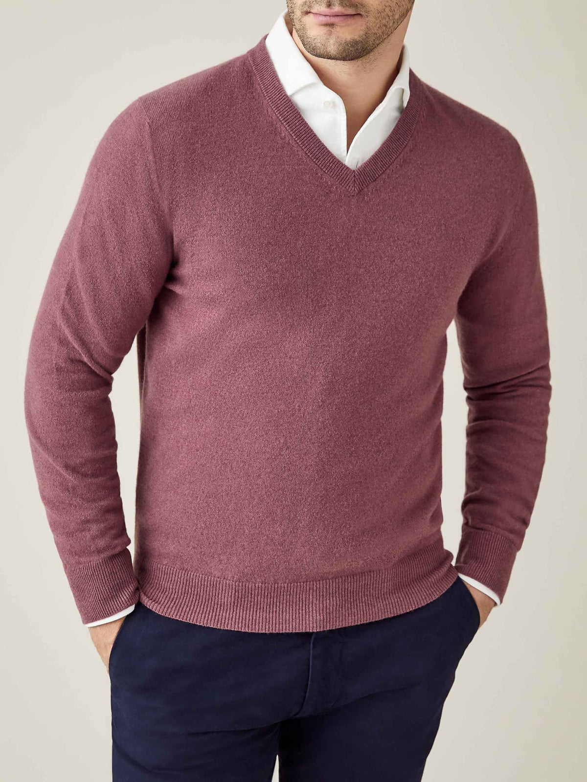 Model wears the Luca Faloni Cashmere V-Neck in Desert Rose, layered over a white shirt and paired with navy trousers.