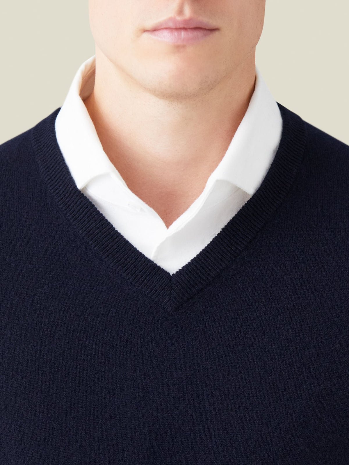 Man wearing the Midnight Blue Cashmere V Neck layered over a white shirt, with a close-up view of the ribbed neckline.
