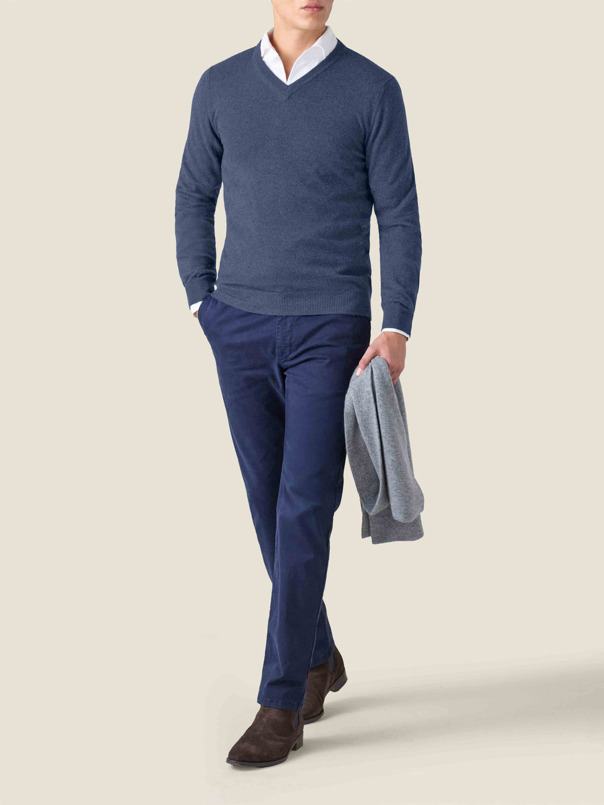 Model wears the Atlantic Blue Cashmere V Neck from Luca Faloni, styled over a white shirt with navy blue trousers.