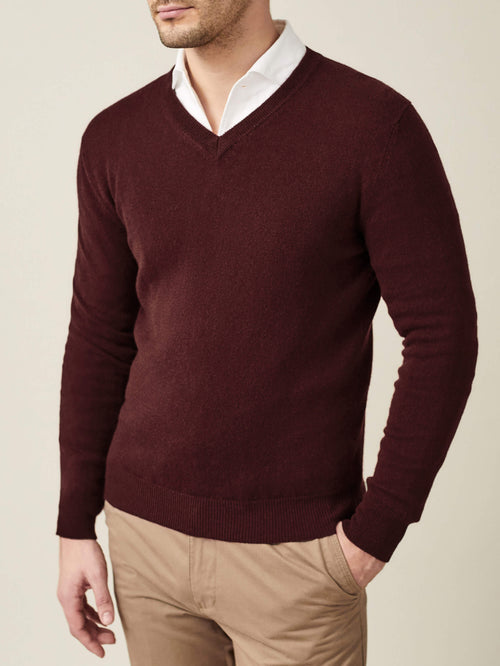 Man wearing the Luca Faloni Lava Red Cashmere V Neck sweater with a white collared shirt and beige chinos.