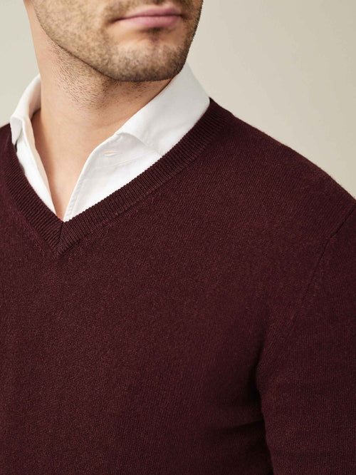 Close-up of the Lava Red Pure Cashmere V Neck, showing the ribbed neckline detail when layered over a white shirt.