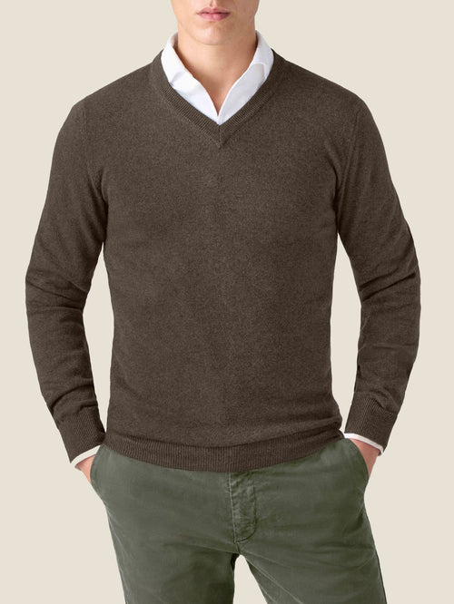 Front view of a model wearing the Chocolate Brown Cashmere V Neck Jumper, layered over a white shirt with green trousers.