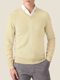 Luca Faloni's yellow pure cashmere V-neck sweater, shown on a model layered over a white shirt and paired with grey trousers.