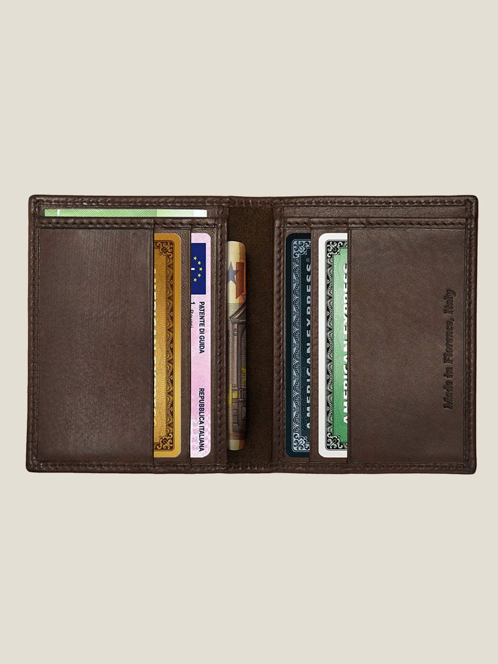 Interior view of the chocolate brown leather bifold cardholder, filled with cards and a bill to show its capacity.