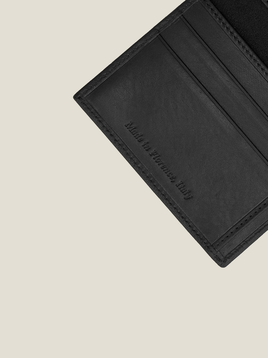 Close-up of the black leather Bifold Cardholder's interior, showing card slots and 'Made in Florence, Italy' embossing.