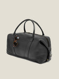 Side view of the Luca Faloni Weekender bag in black leather, with sunglasses tucked into the external sleeve pocket.