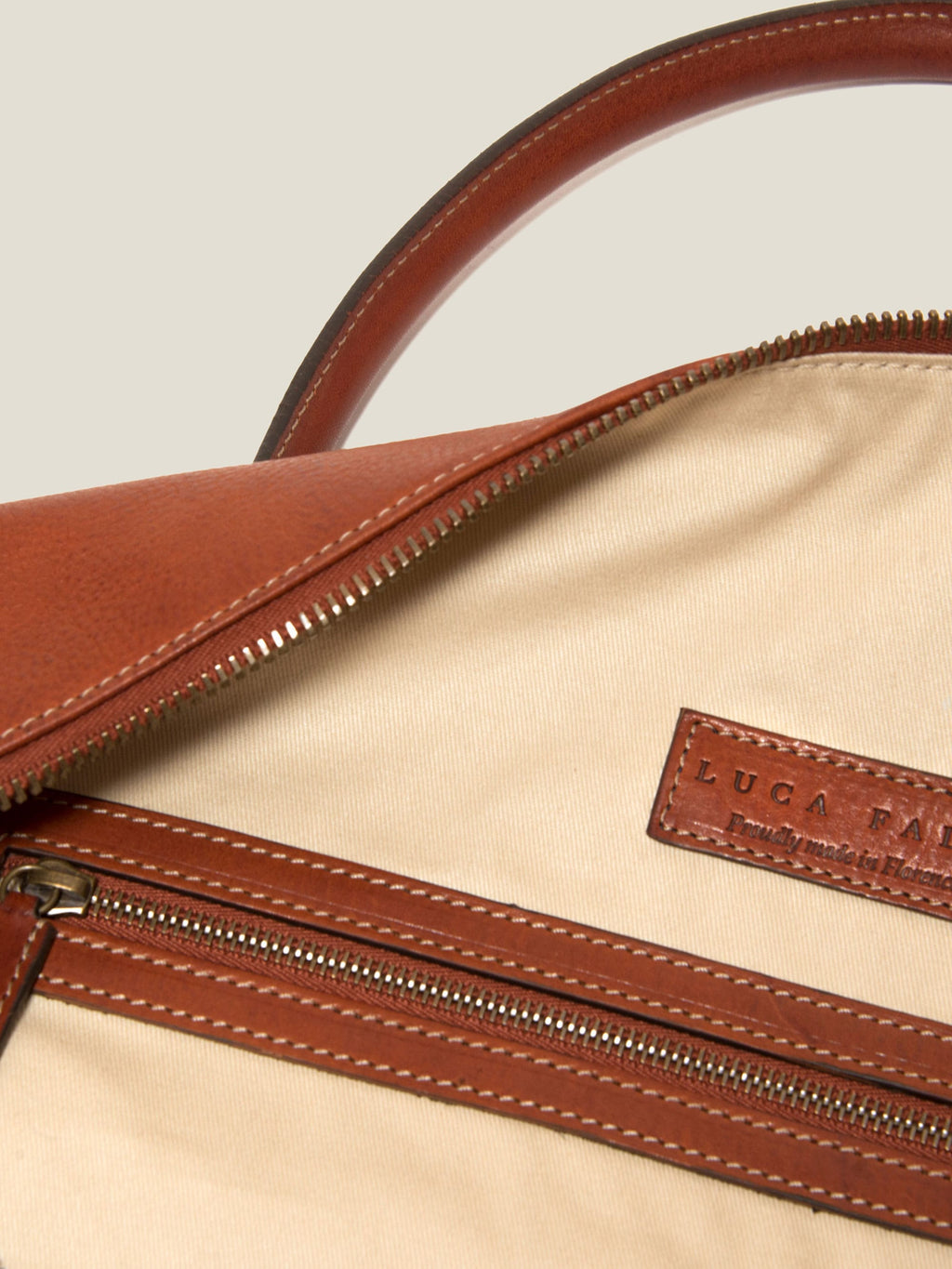 Interior detail of the Caramel Brown Leather Weekender, showing the internal zip pocket and Luca Faloni logo tab.