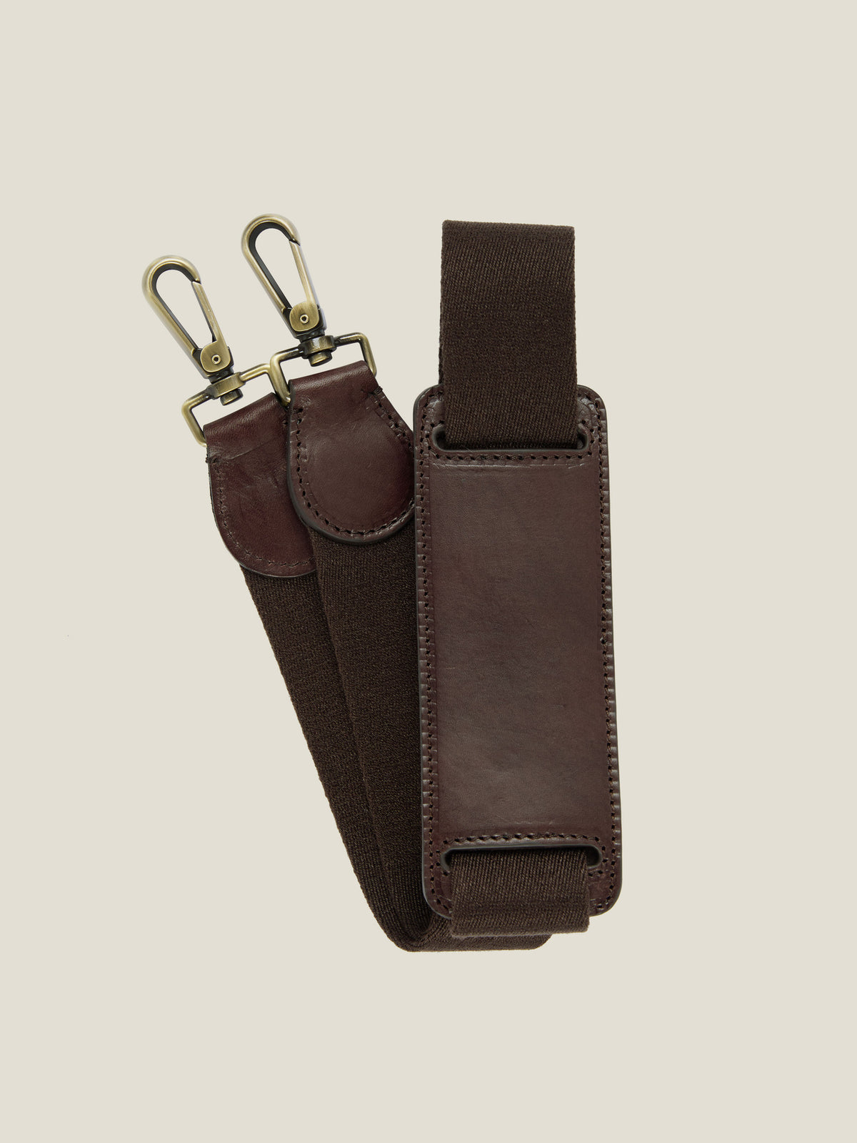 Close-up of the detachable shoulder strap for the Chocolate Brown Weekender, featuring a leather pad and metal clasps.