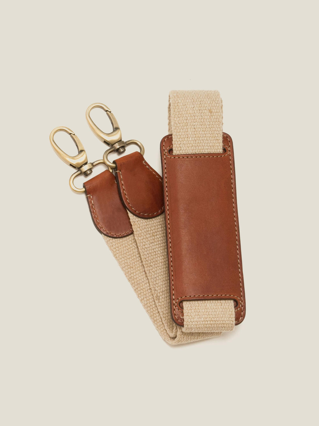 Close-up of the detachable strap for the Caramel Brown Weekender bag, showing the leather shoulder pad and brass clasps.