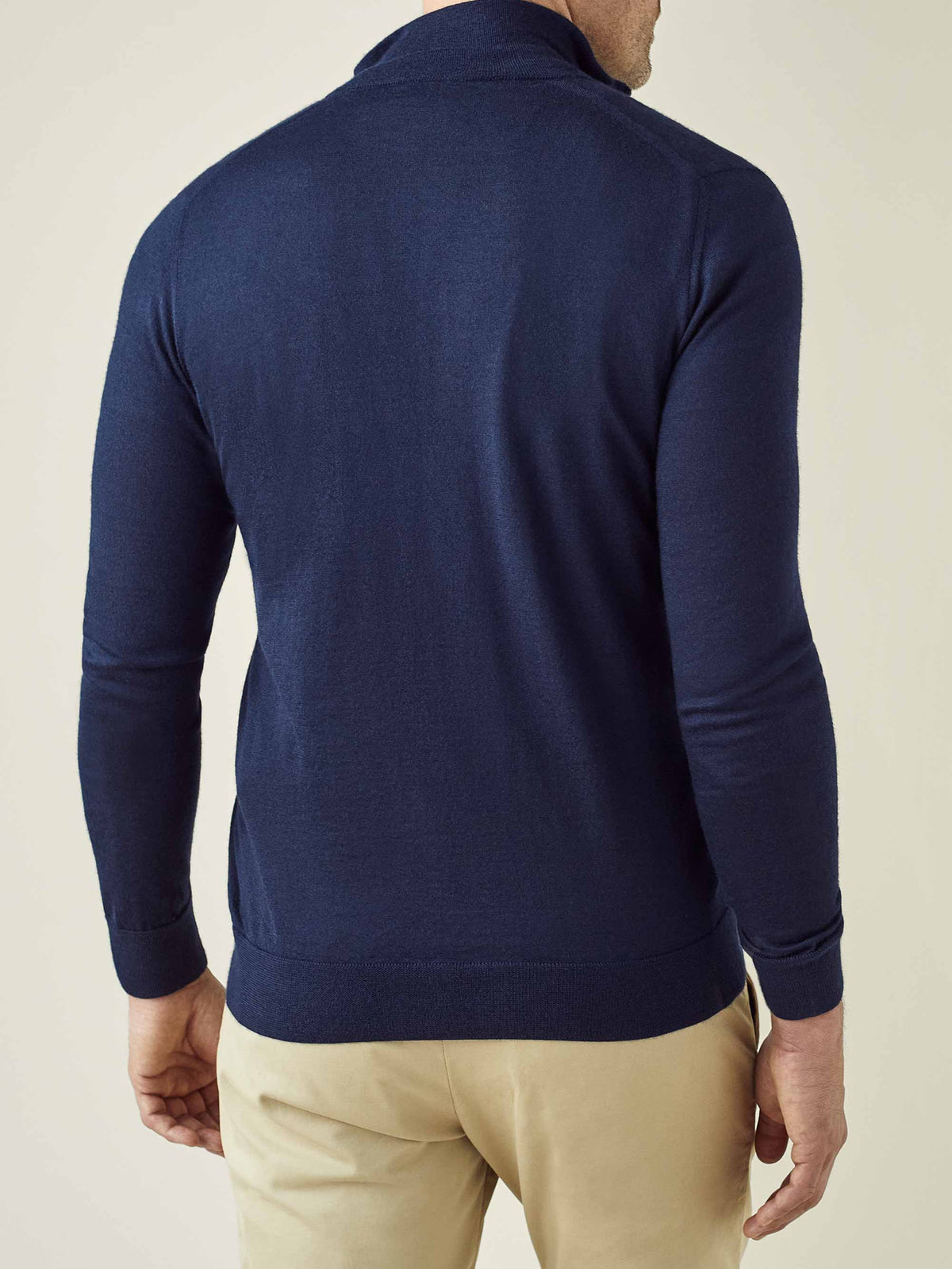 A rear view of a model wearing the Luca Faloni Silk-Cashmere Zip Cardigan in navy blue, showcasing its clean lines and fit.