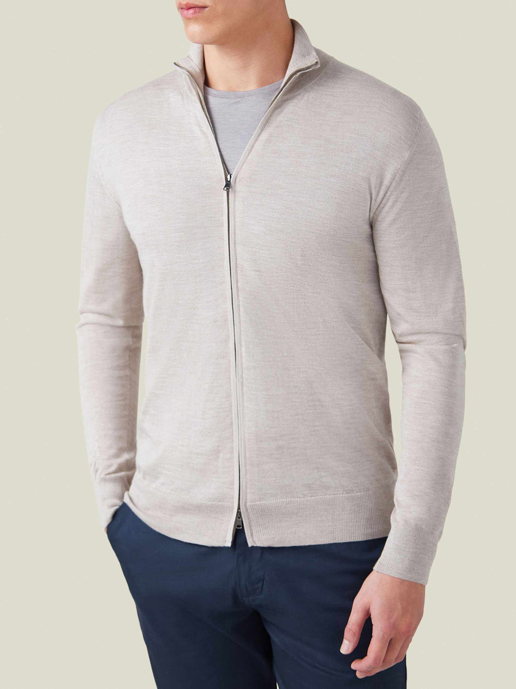 Front view of a model wearing the Luca Faloni Silk-Cashmere Zip Cardigan in Oatmeal over a grey t-shirt.