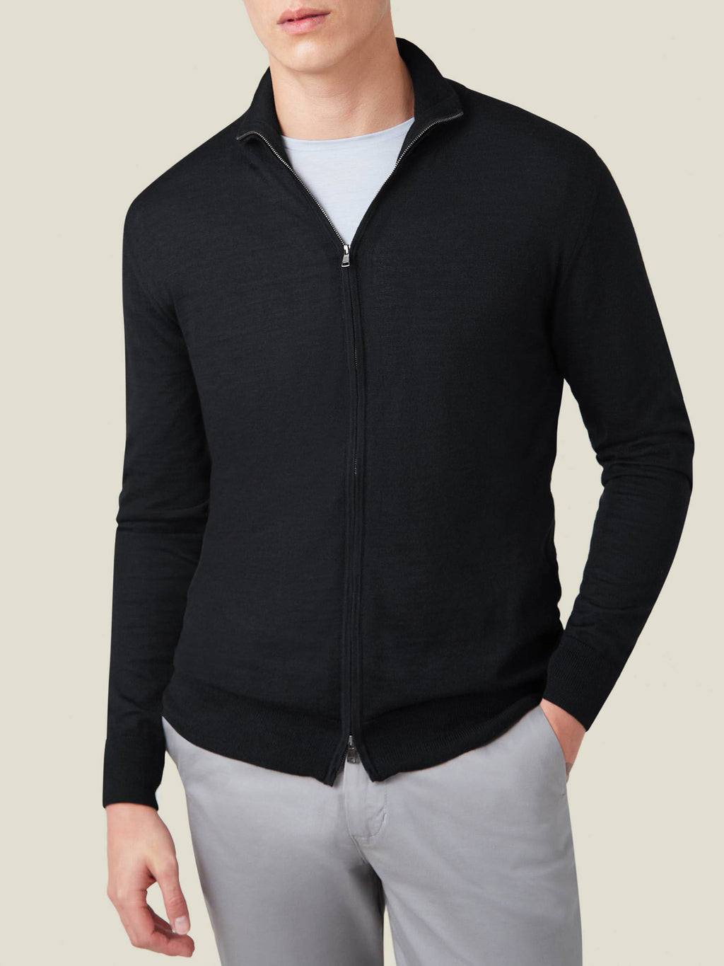 A front view of a model wearing the Luca Faloni Black Silk-Cashmere Zip Cardigan over a t-shirt and light grey trousers.