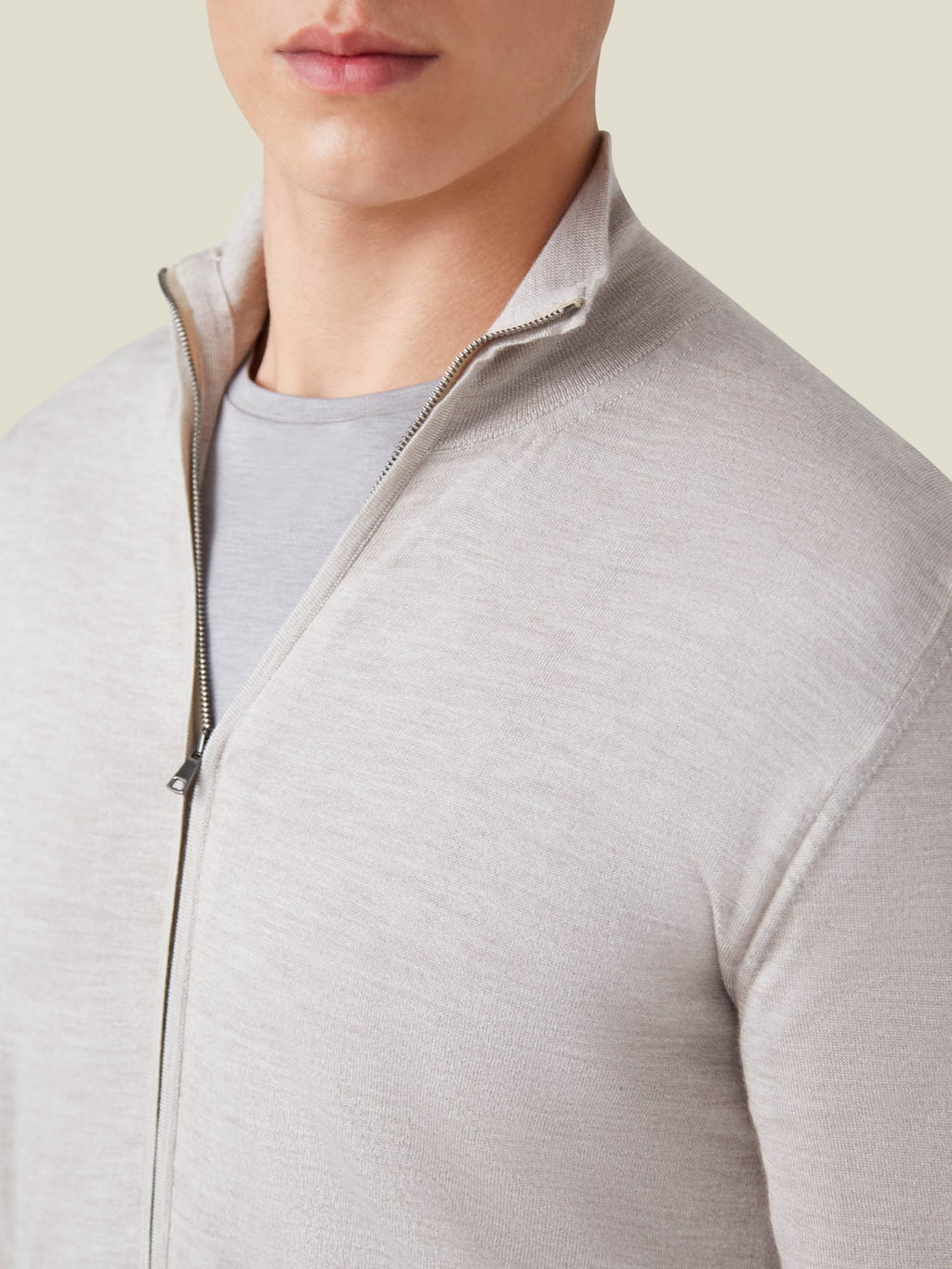 A close-up shot of a model wearing the Oatmeal Silk-Cashmere Zip Cardigan, highlighting its fine knit and funnel neck.