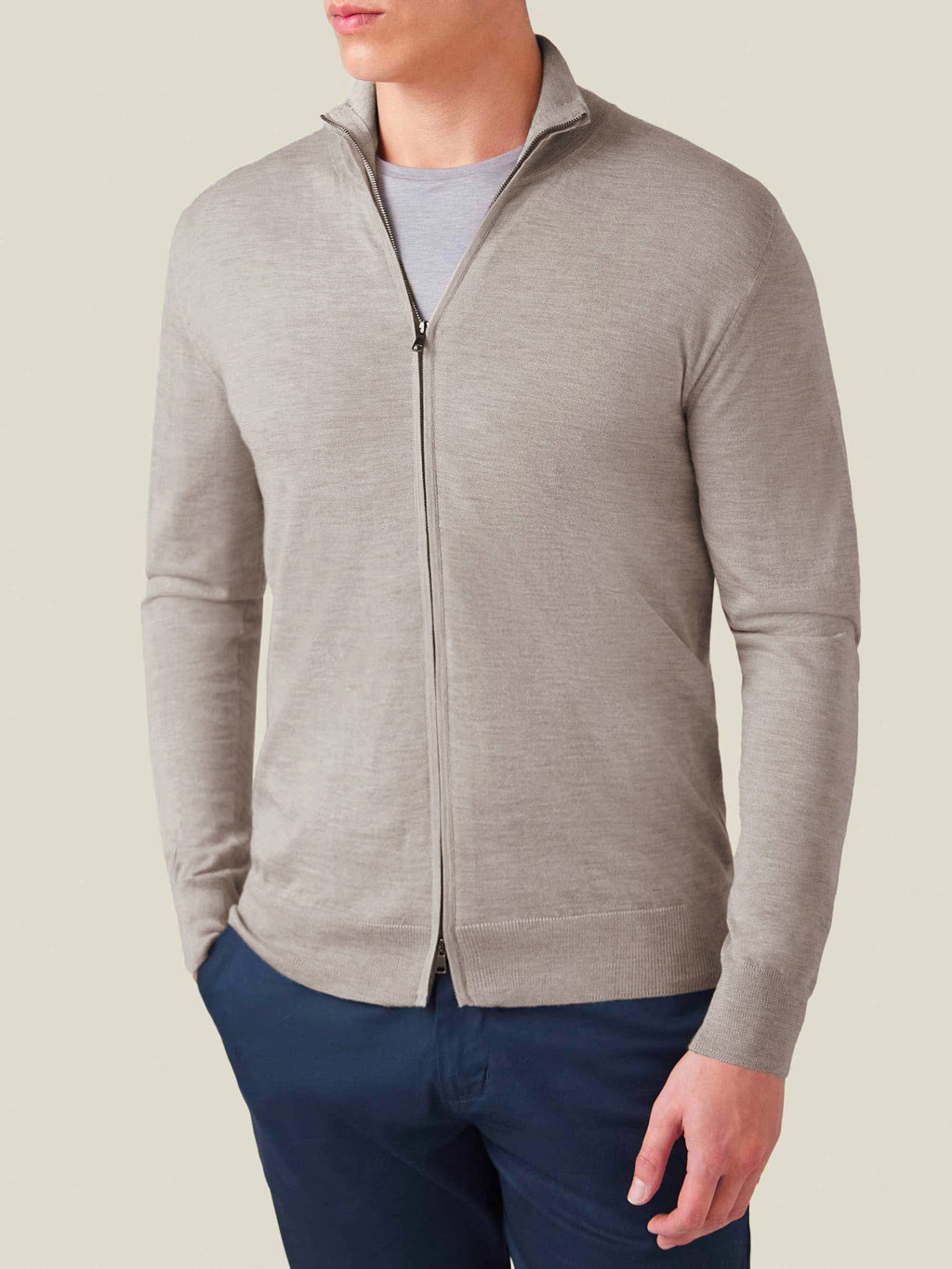 A model wears the Nocciola Brown Silk-Cashmere Zip Cardigan, layered over a grey t-shirt and dark blue trousers.