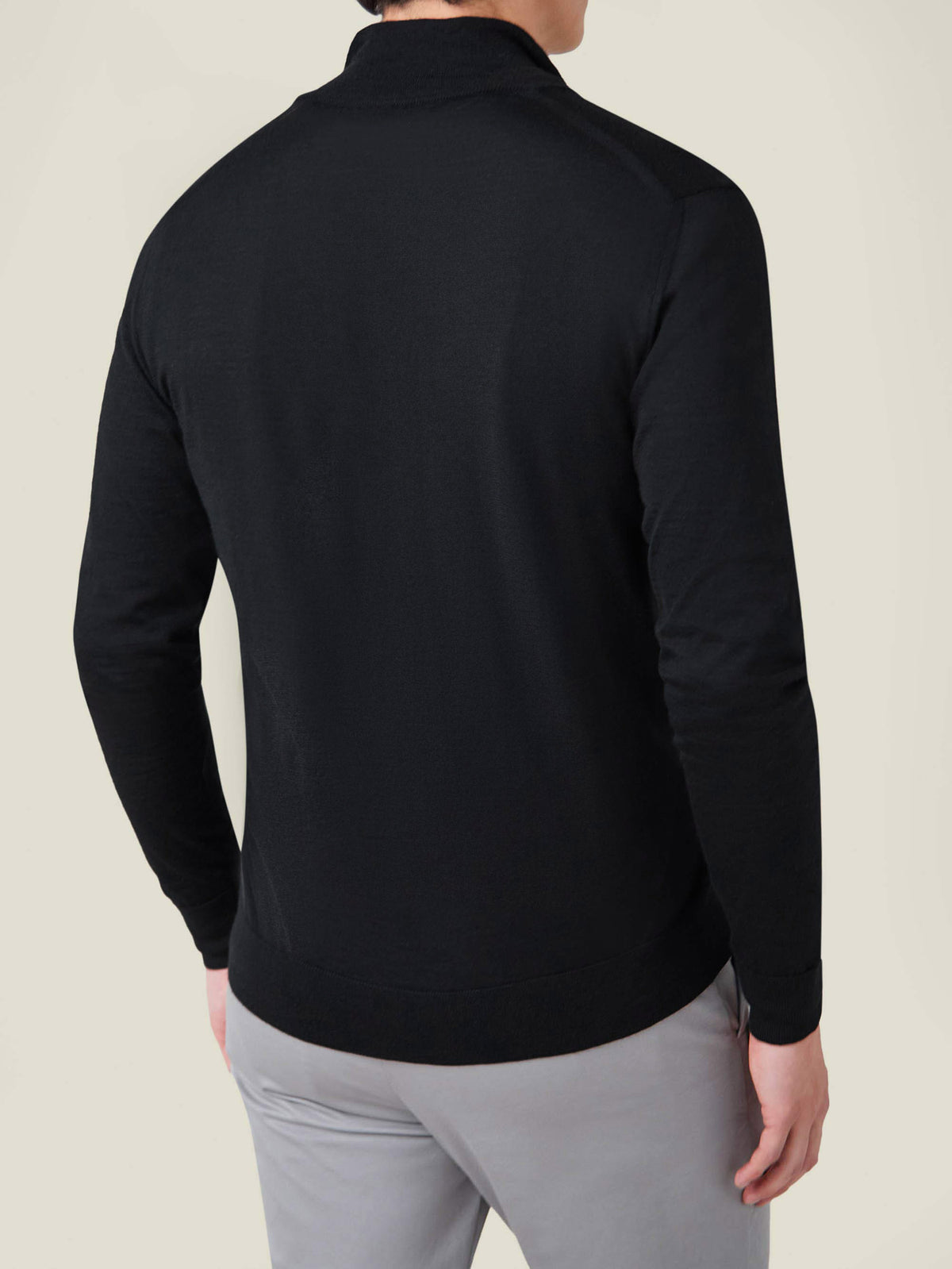 Rear view of a model wearing the Luca Faloni Black Silk-Cashmere Zip Cardigan, highlighting its sleek fit and ribbed hem.