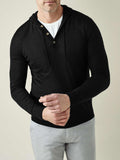 A man models the Black Silk-Cashmere Hoodie over a white t-shirt and light grey trousers, adjusting the cuff.