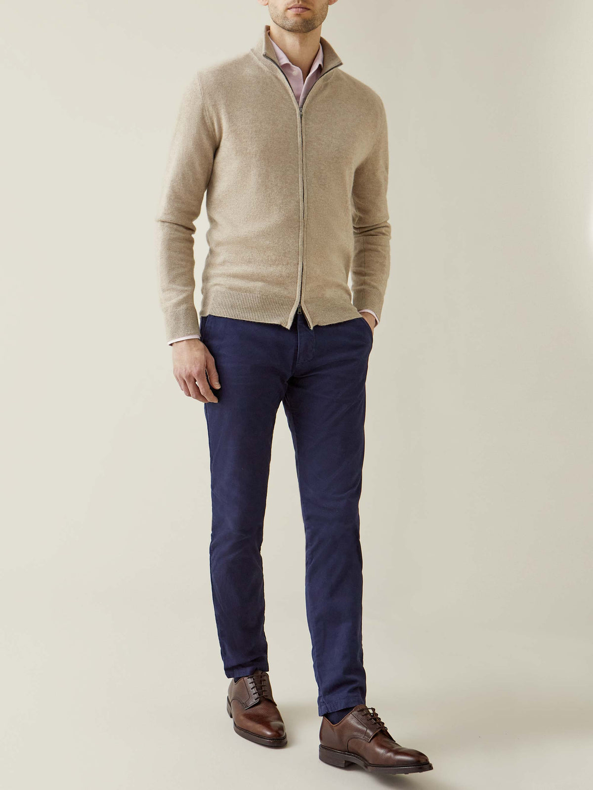 Model wearing the Luca Faloni Camel Beige Cashmere Zip Cardigan layered over a shirt with navy trousers and brown shoes.