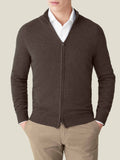 Front view of a man wearing a chocolate brown cashmere zip cardigan over a white shirt and beige trousers.