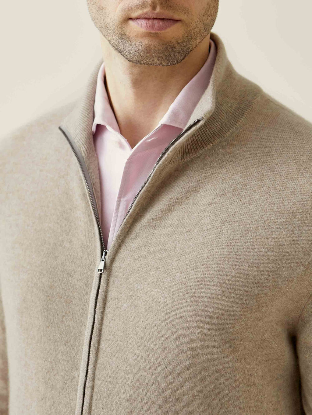 Close-up of a man wearing the Camel Beige Cashmere Zip Cardigan, showing the ribbed funnel collar and soft fabric texture.