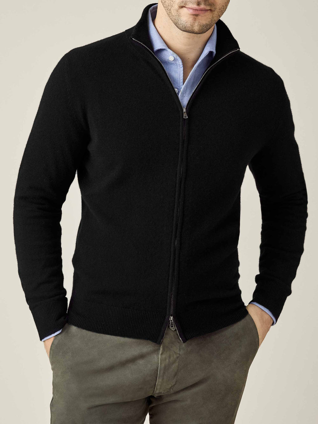 Front view of a model wearing the Luca Faloni Black Cashmere Zip Cardigan over a light blue shirt and grey trousers.