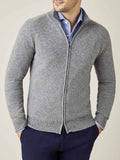 Model wears the Luca Faloni cashmere zip cardigan in Dolomiti grey, styled over a blue shirt and navy trousers.