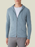 Model seen from the front wearing the French Blue Cashmere Zip Hoodie, styled open with a white t-shirt and grey trousers.