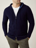 Man wearing the Luca Faloni Cashmere Zip Hoodie in Midnight Blue, styled open over a white t-shirt and olive trousers.
