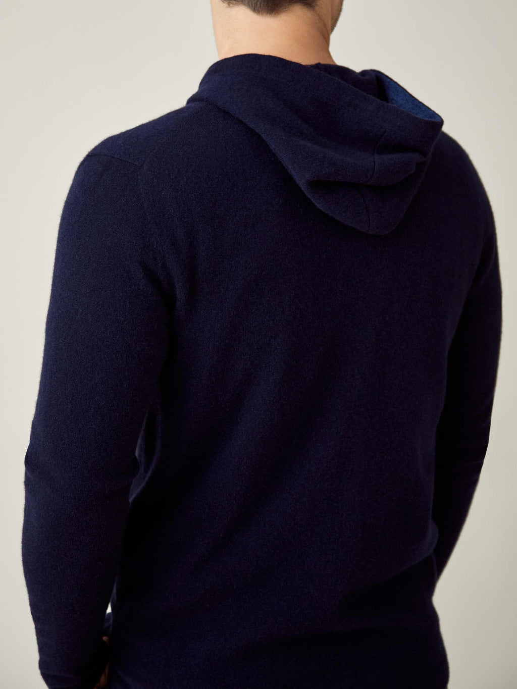 Back view of a model wearing the Luca Faloni cashmere zip hoodie in midnight blue.