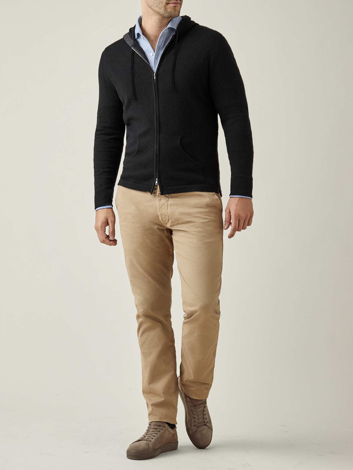 Full-length front view of a man wearing the Luca Faloni black cashmere zip hoodie, styled with khaki chinos and a blue shirt.