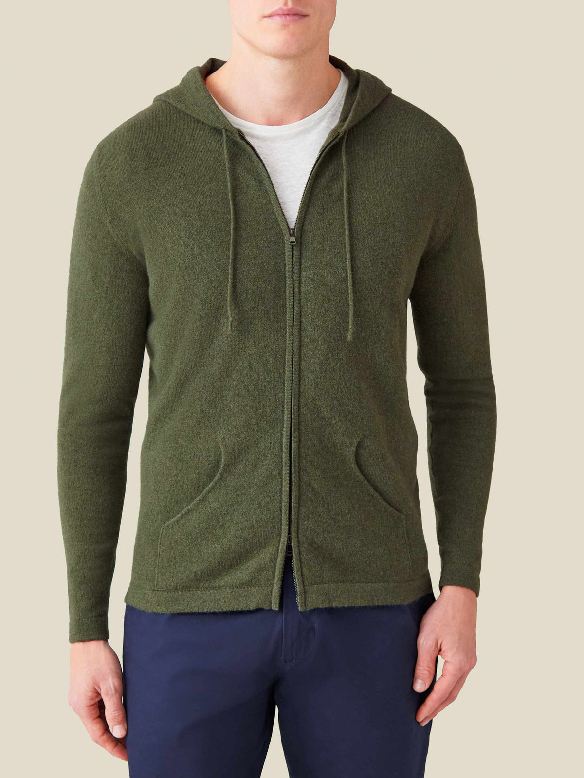 Front view of a man wearing the Luca Faloni Cashmere Zip Hoodie in Hunting Green with a white t-shirt and navy trousers.