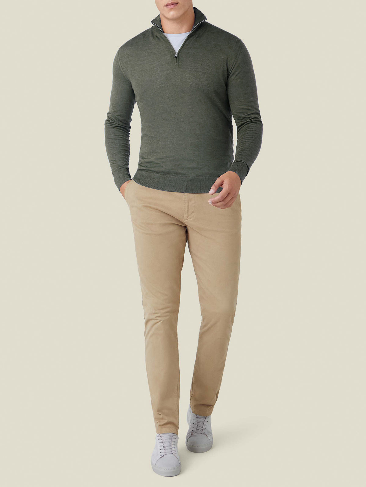 Full-body front view of a model in a Moss Green Silk-Cashmere Zip-up, paired with beige chinos and grey sneakers.