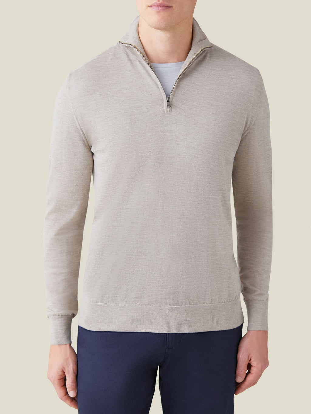 Front view of a man wearing the oatmeal silk-cashmere zip-up jumper, layered over a light grey t-shirt.