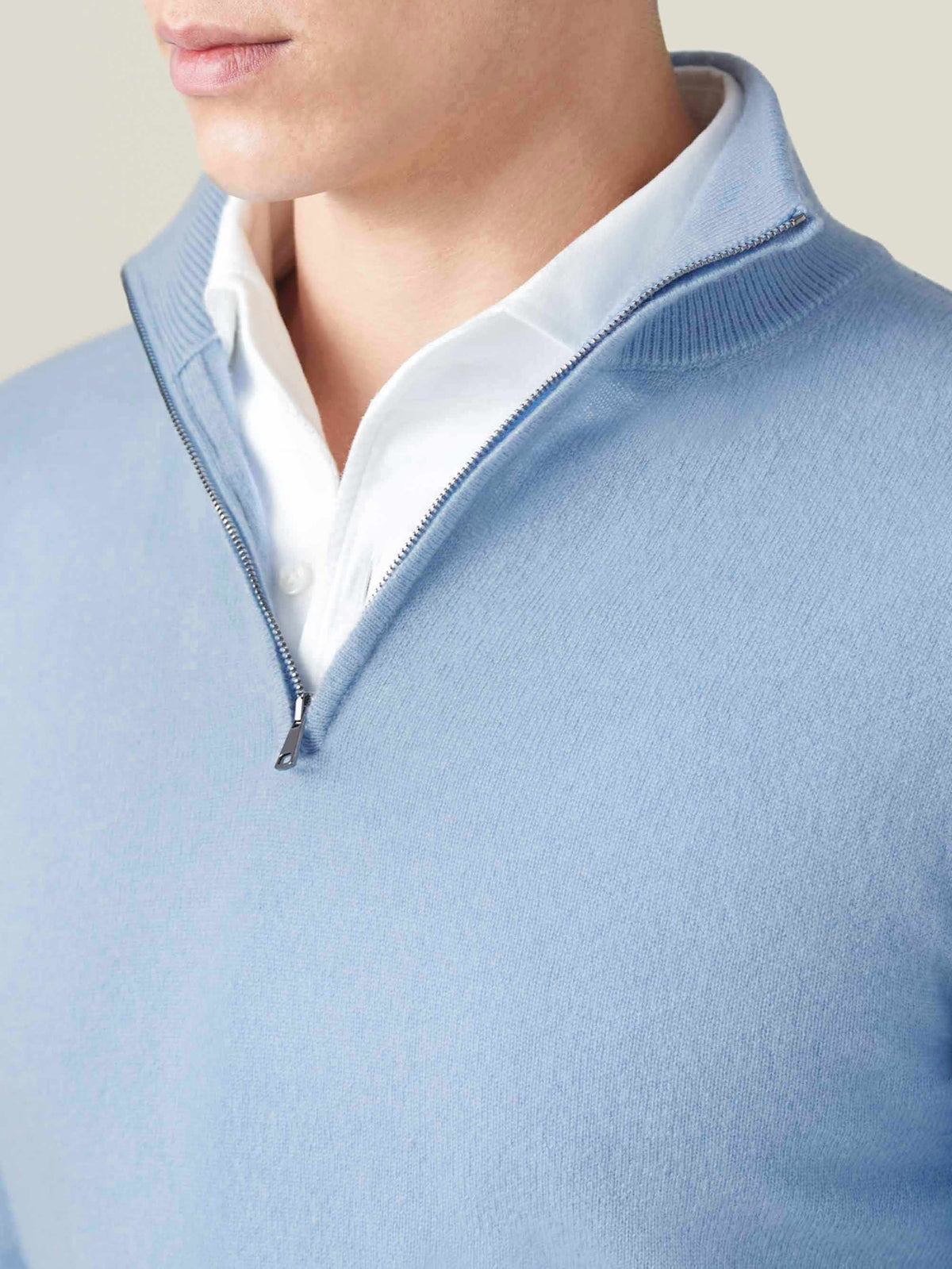 Close-up detail of the Luca Faloni sky blue cashmere zip-up, showing the ribbed collar and premium zip over a white shirt.
