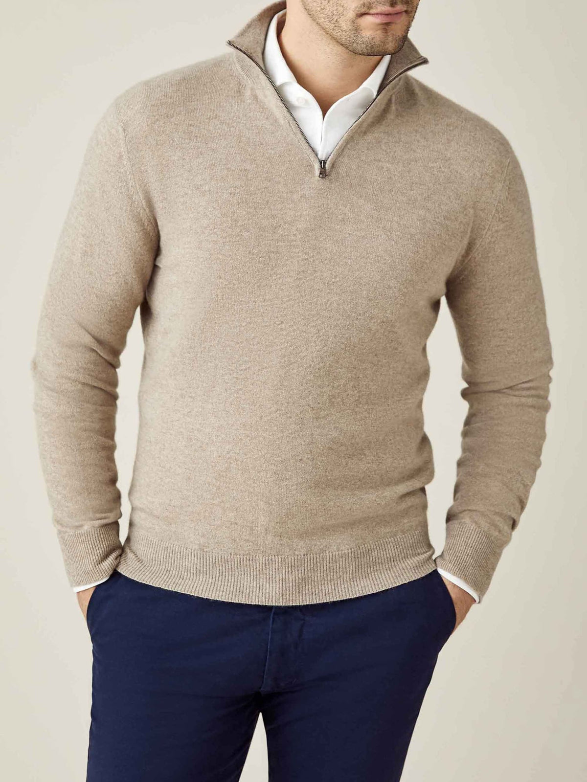 Front view of a model wearing the Luca Faloni camel beige cashmere zip-up sweater styled with a white shirt and navy chinos.