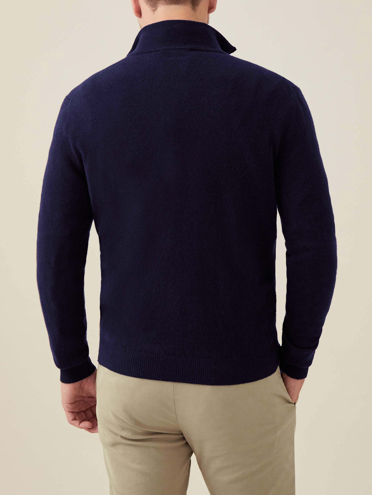 Back view of a man wearing the Luca Faloni Cashmere Zip-up in midnight blue, paired with light-coloured trousers.